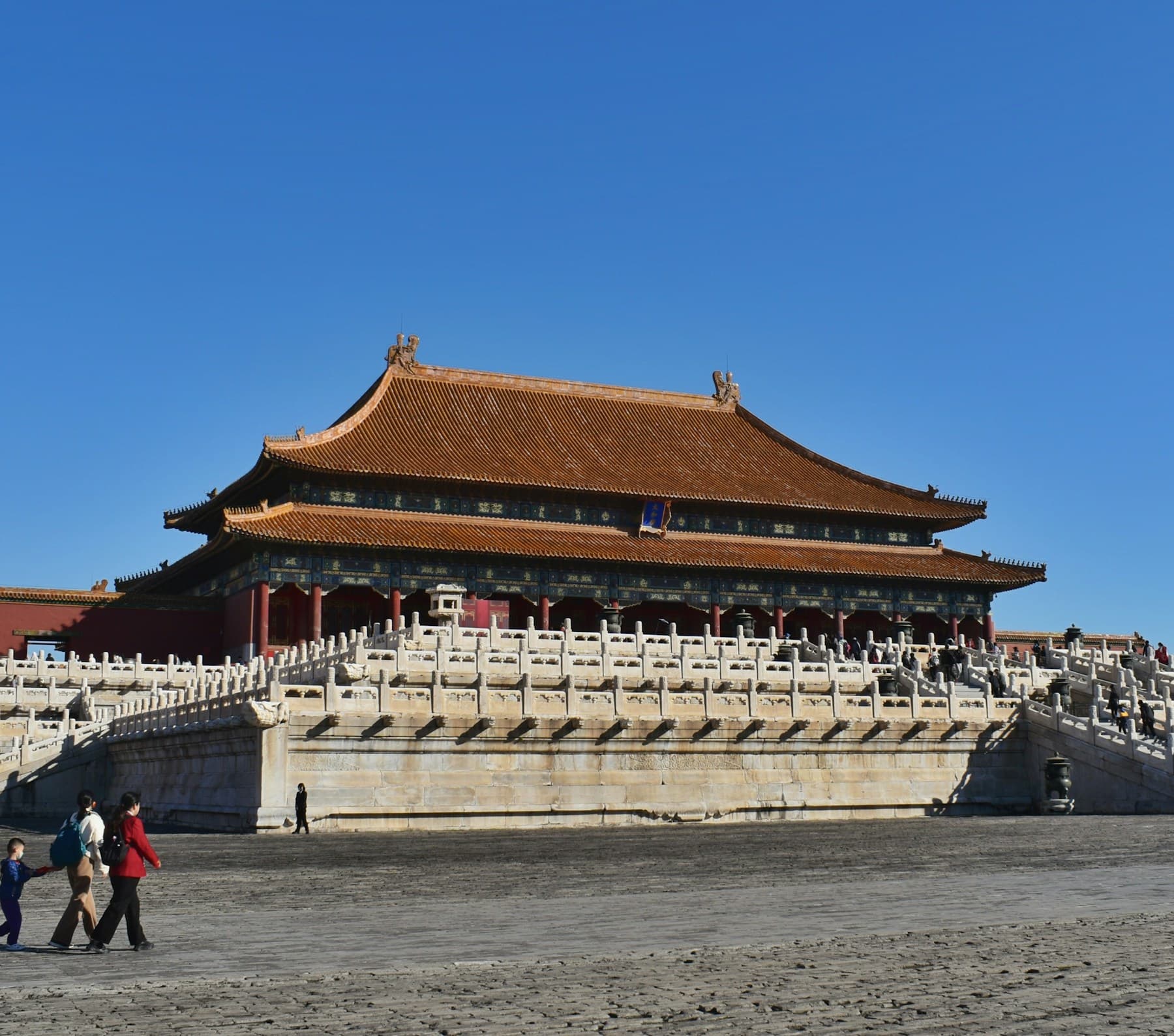 A Forbidden City palace hall beneath a clear blue Beijing sky