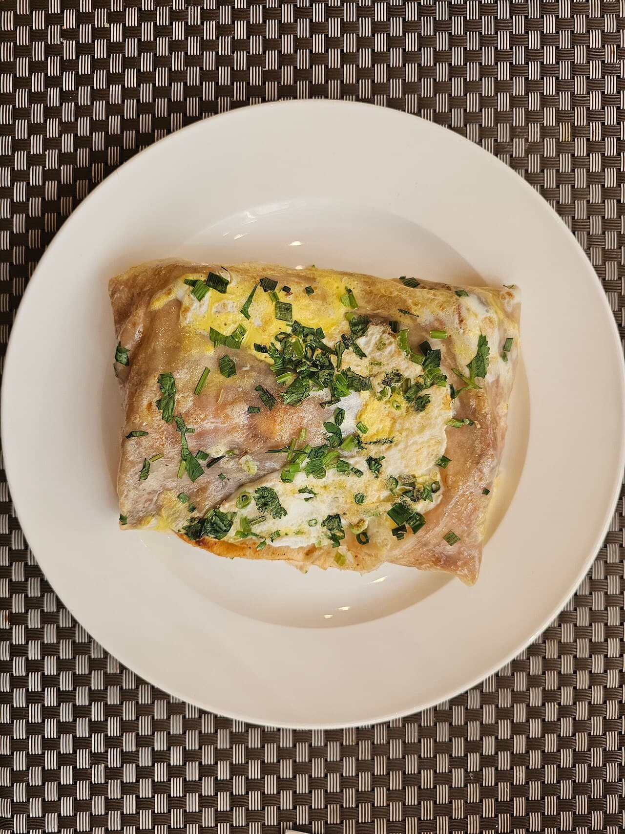 A folded jianbing breakfast crepe with egg and scallions
